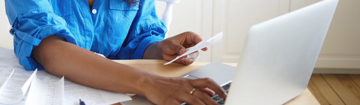 female using online banking on laptop at home 